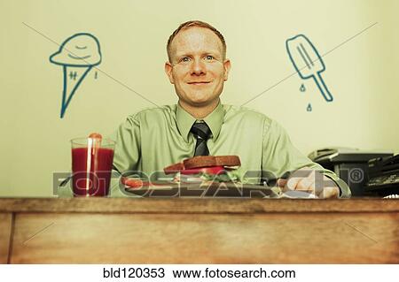 Stock Image - Caucasian businessman eating lunch. Fotosearch