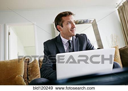 Stock Photo - Caucasian businessman using laptop. Fotosearch