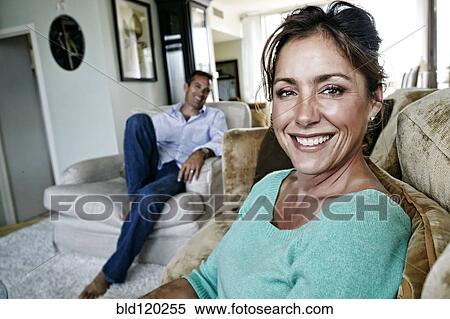 Stock Photography - Caucasian couple relaxing in living room. Fotosearch