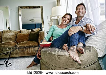 Picture - Caucasian couple relaxing in livingroom. Fotosearch