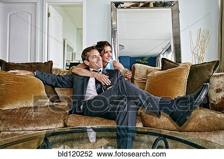 Caucasian couple relaxing on sofa View Large Photo Image Stock Image - Caucasian couple relaxing on sofa. Fotosearch