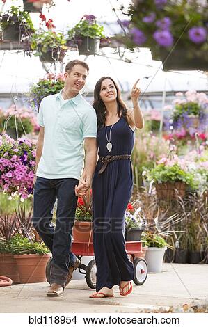 Picture - Caucasian couple shopping in plant nursery. Fotosearch