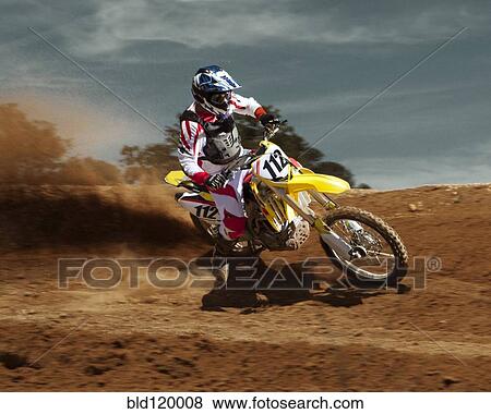 Stock Photo - Caucasian dirt bike rider on course. Fotosearch