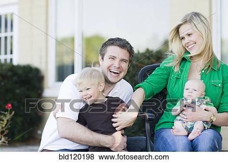 Stock Photo - Caucasian family relaxing outdoors. Fotosearch