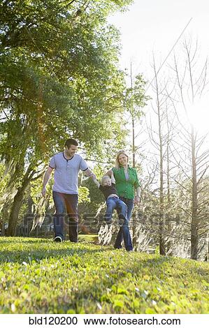 Caucasian family walking in park View Large Photo Image Stock Image - Caucasian family walking in park. Fotosearch