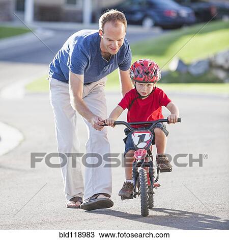 Caucasian father teaching son to ride bicycle View Large Photo Image Stock Image - Caucasian father teaching son to ride bicycle. Fotosearch