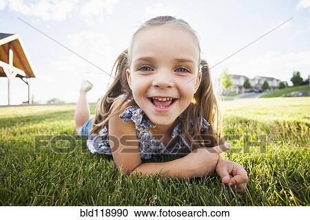 Caucasian girl laying in grass View Large Photo Image Stock Image - Caucasian girl laying in grass. Fotosearch