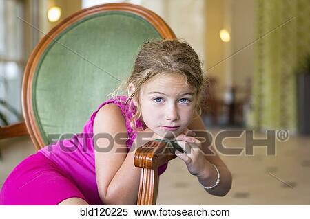 Stock Photography - Caucasian girl sitting in chair. Fotosearch