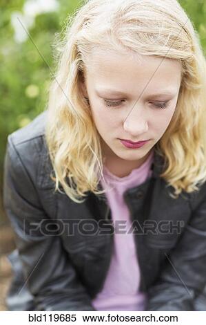 Stock Photography - Caucasian girl sitting outdoors. Fotosearch