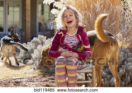Stock Photography - Caucasian girl sitting with dog outdoors. Fotosearch