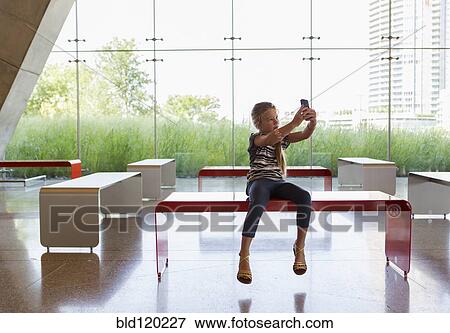 Caucasian girl taking self-portrait in lobby View Large Photo Image Stock Photo - Caucasian girl taking self-portrait in lobby. Fotosearch