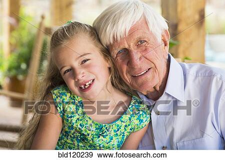 Stock Photo - Caucasian man and granddaughter smiling. Fotosearch