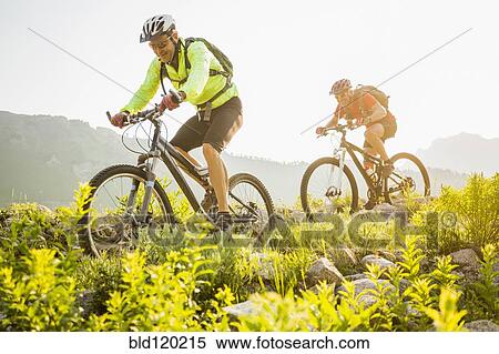 Stock Photography - Caucasian men riding mountain bikes on trail. Fotosearch