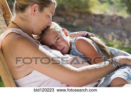 Stock Image - Caucasian mother and daughter relaxing outdoors. Fotosearch