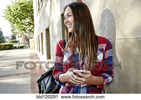 Stock Image - Caucasian student smiling on campus. Fotosearch