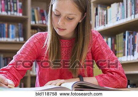Stock Photo - Caucasian student taking notes in library. Fotosearch