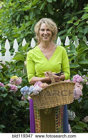 Stock Photo - Caucasian woman gathering flowers. Fotosearch