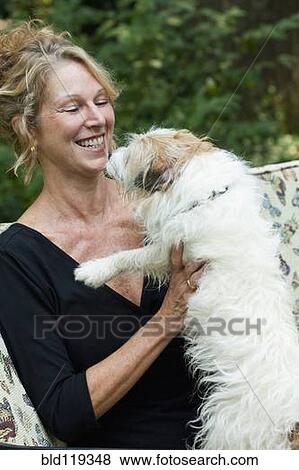 Stock Photo - Caucasian woman playing with dog. Fotosearch