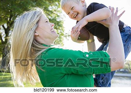 Stock Photo - Caucasian woman playing with son. Fotosearch