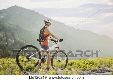 Caucasian woman with mountain bike looking at view View Large Photo Image Stock Photo - Caucasian woman with mountain bike looking at view. Fotosearch