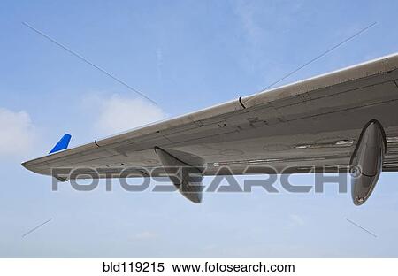 Stock Photography - Close up of airplane wing against blue sky. Fotosearch