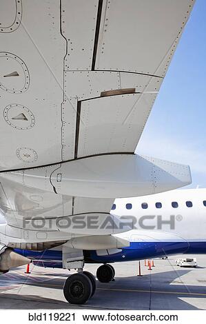 Close up of airplane wing on runway View Large Photo Image Stock Image - Close up of airplane wing on runway. Fotosearch
