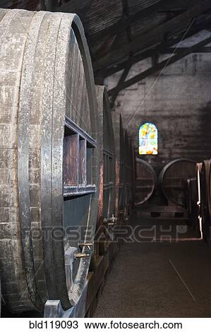 Stock Image - Close up of wine barrels in cellar. Fotosearch