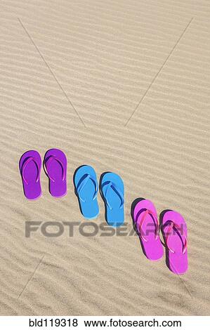 Stock Photo - Colorful flip flops on sand. Fotosearch