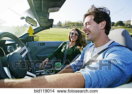 Picture - Couple driving in convertible. Fotosearch