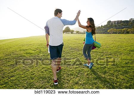 Couple high fiving in park View Large Photo Image Stock Image - Couple high fiving in park. Fotosearch