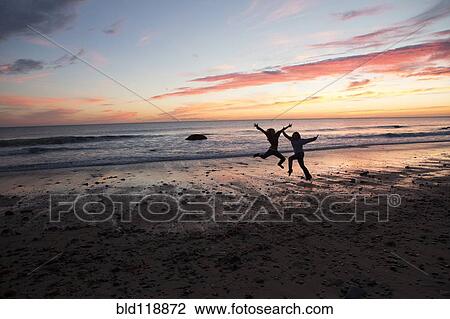 Stock Image - Couple playing on beach. Fotosearch
