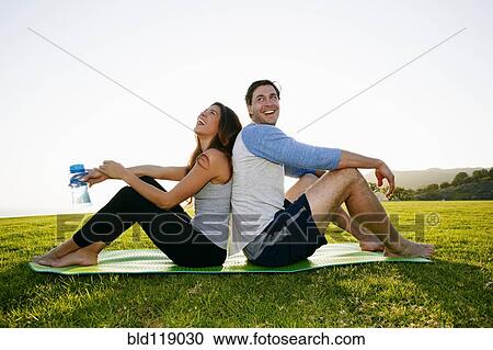 Couple sitting on yoga mat in park View Large Photo Image Stock Image - Couple sitting on yoga mat in park. Fotosearch