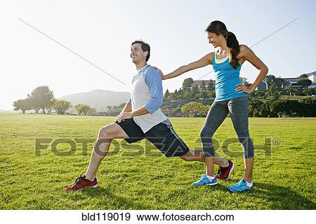Stock Photo - Couple stretching in park. Fotosearch