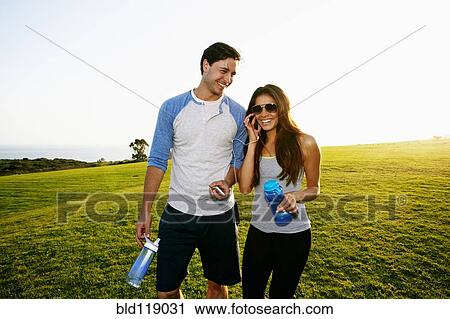 Stock Image - Couple walking together in park. Fotosearch