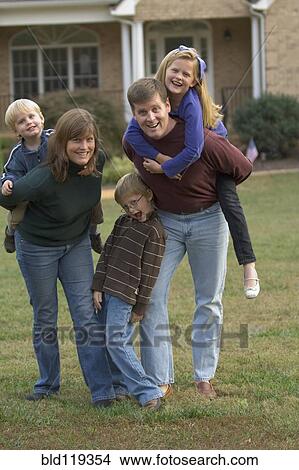 Family playing together on front lawn View Large Photo Image Picture - Family playing together on front lawn. Fotosearch