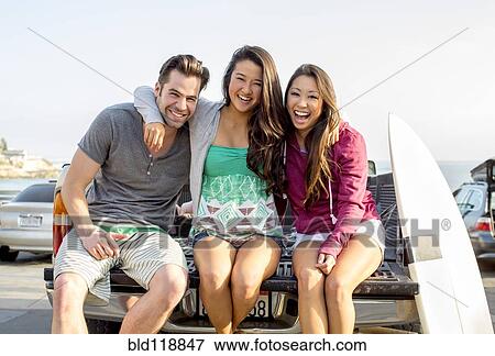 Stock Photo - Friends relaxing together on truck bed. Fotosearch