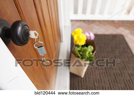 Picture - Groceries and keys on front porch of house. Fotosearch