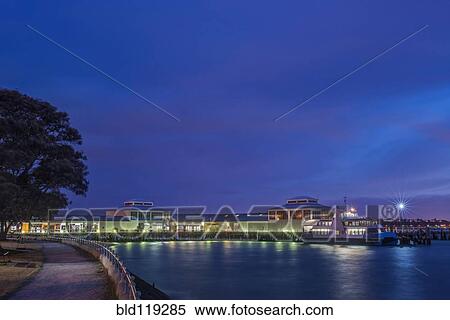 Stock Photography - Harbor and boat lit up at dusk. Fotosearch