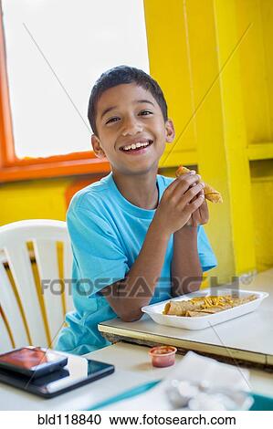 Hispanic boy eating in restaurant View Large Photo Image Stock Image - Hispanic boy eating in restaurant. Fotosearch