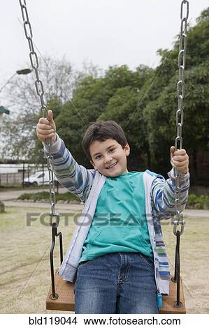 Hispanic boy playing on swing View Large Photo Image Picture - Hispanic boy playing on swing. Fotosearch