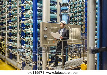 Hispanic businessman checking machinery View Large Photo Image Stock Image - Hispanic businessman checking machinery. Fotosearch