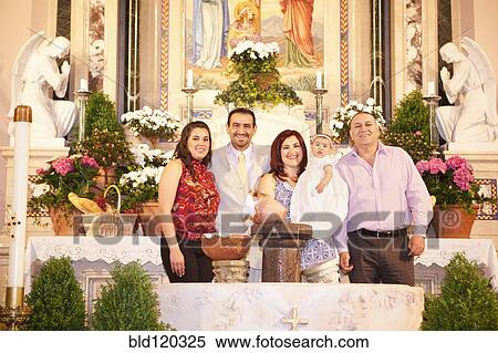 Stock Photography - Hispanic family smiling by religious relics. Fotosearch