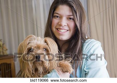 Stock Photograph - Hispanic girl holding dog. Fotosearch