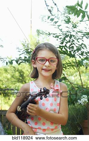 Picture - Hispanic girl holding violin outdoors. Fotosearch