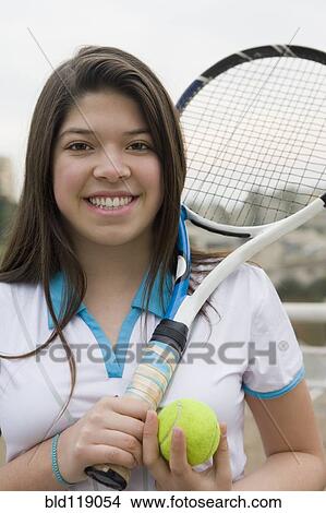 Picture - Hispanic girl playing tennis outdoors. Fotosearch