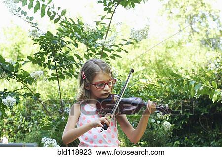 Stock Image - Hispanic girl playing violin outdoors. Fotosearch