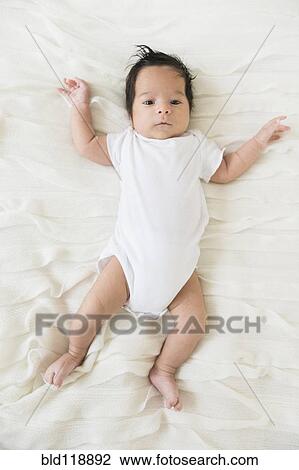 Stock Image - Hispanic infant laying on blanket. Fotosearch