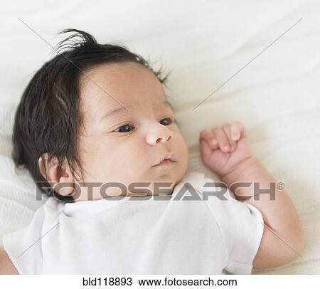 Stock Image - Hispanic infant laying on blanket. Fotosearch