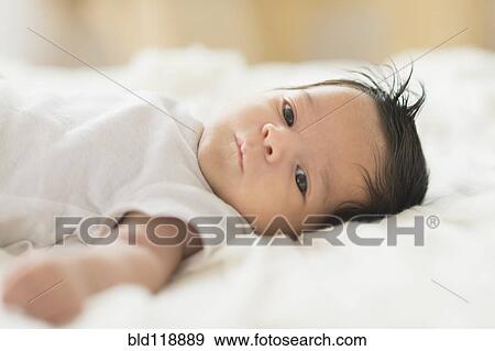 Stock Photo - Hispanic infant laying on blanket. Fotosearch