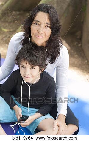 Hispanic mother and son listening to mp3 player View Large Photo Image Picture - Hispanic mother and son listening to mp3 player. Fotosearch